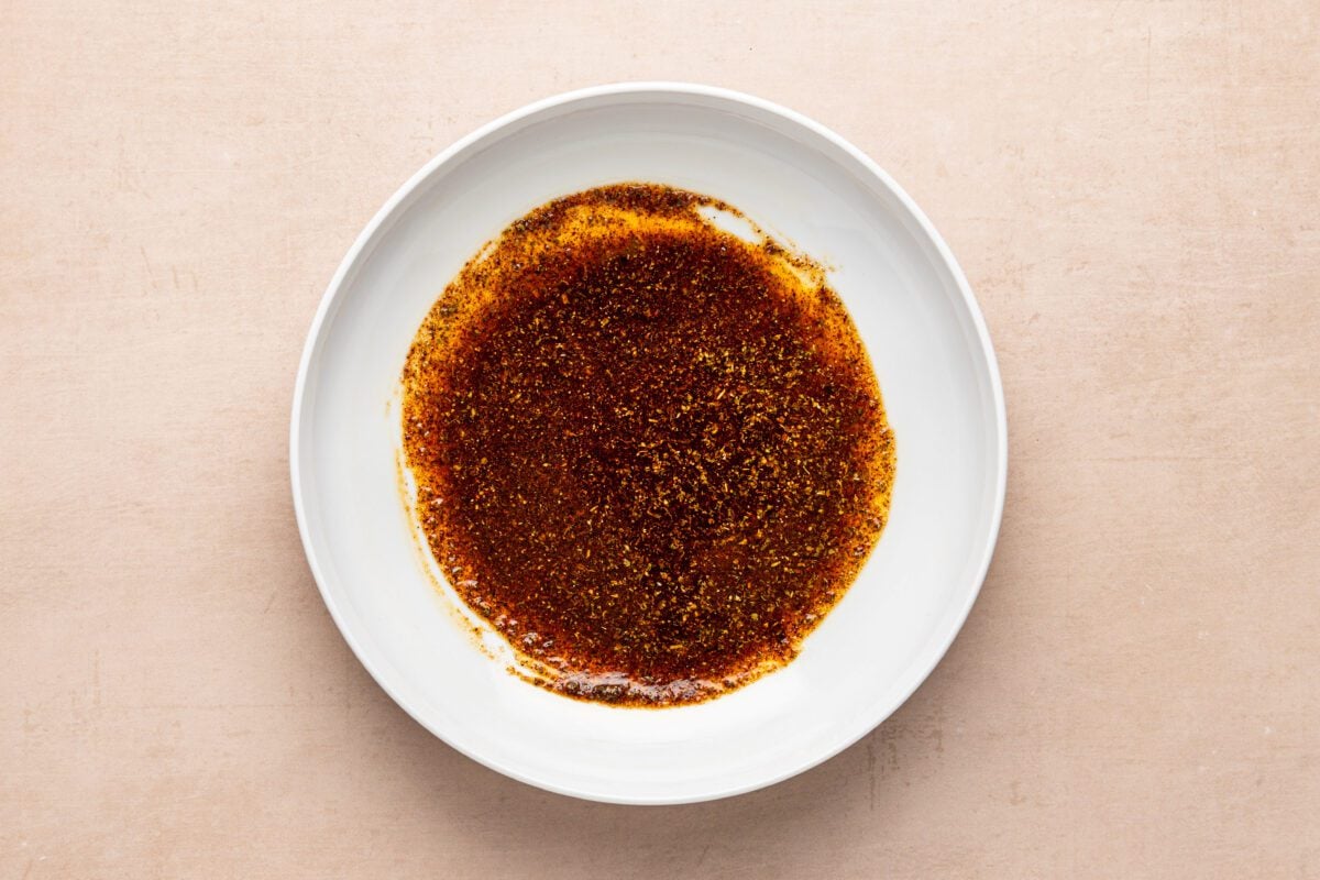 large bowl with oil, salt, chile powder, cumin, oregano, smoked paprika, and garlic powder