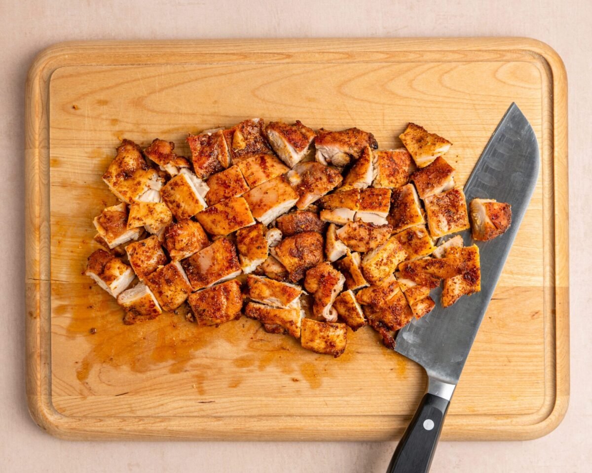 chopped chipotle chicken and knife on wood cutting board