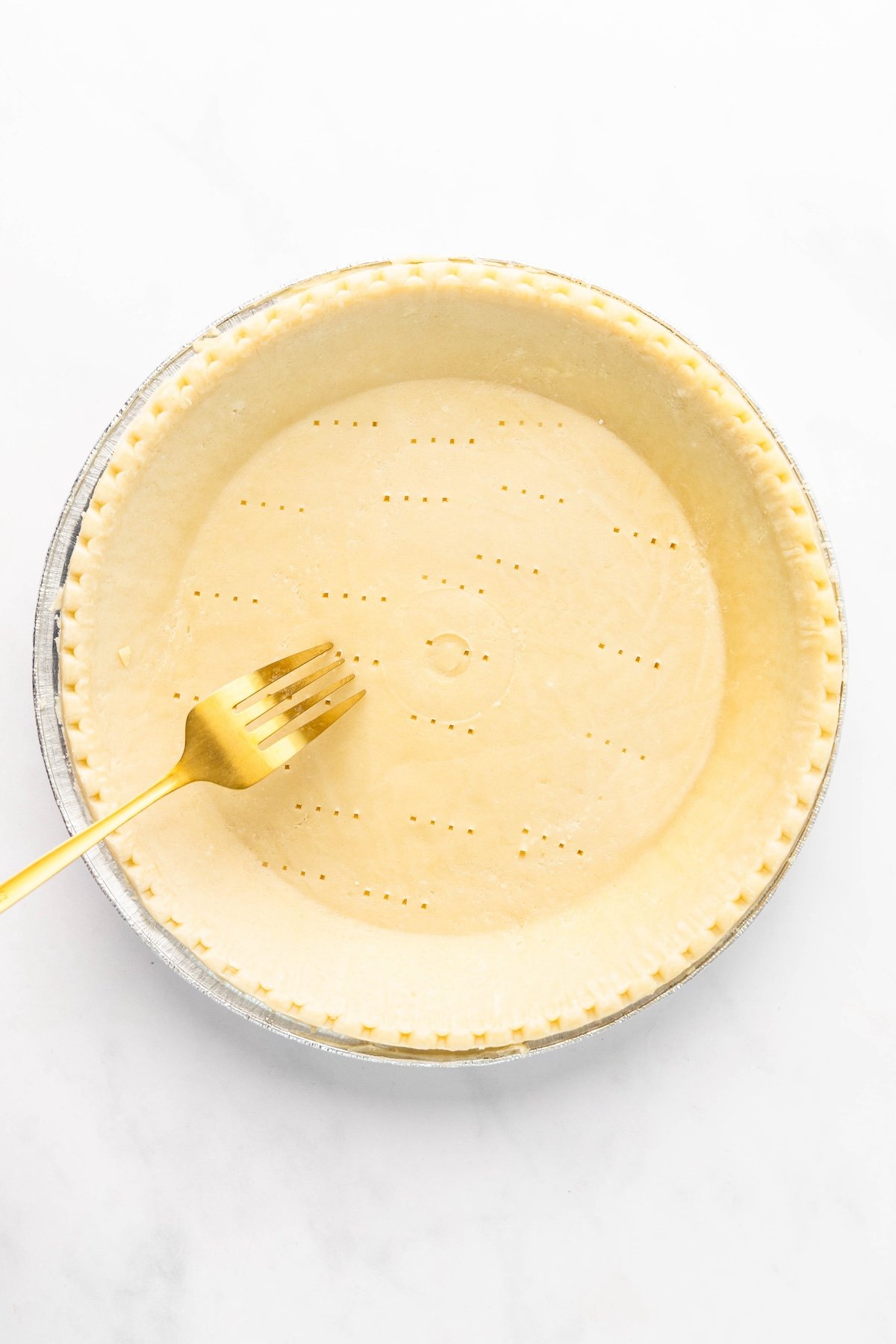 pricking unbaked pie crust with a fork