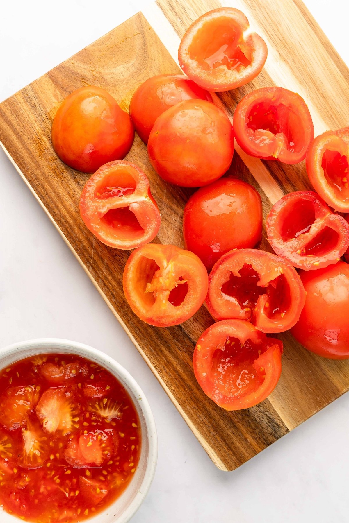 cored and seeded tomatoes on wood cutting board