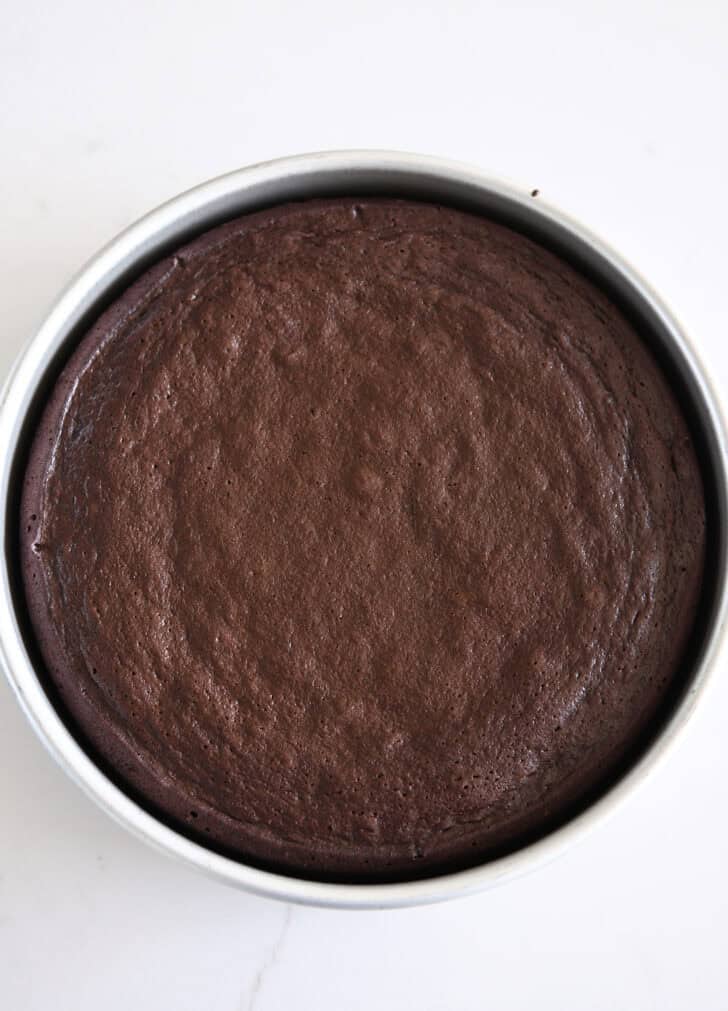 Top down view of baked chocolate olive oil cake in 9-inch circle pan.