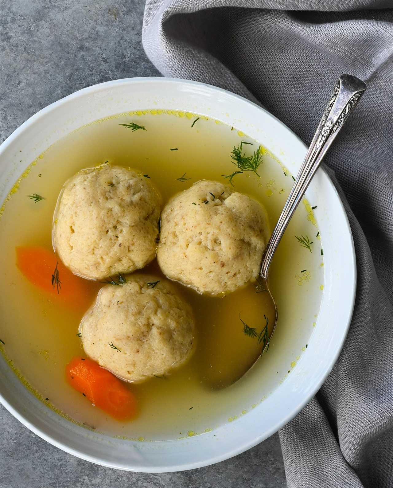 Spoon in a bowl of matzo ball soup.