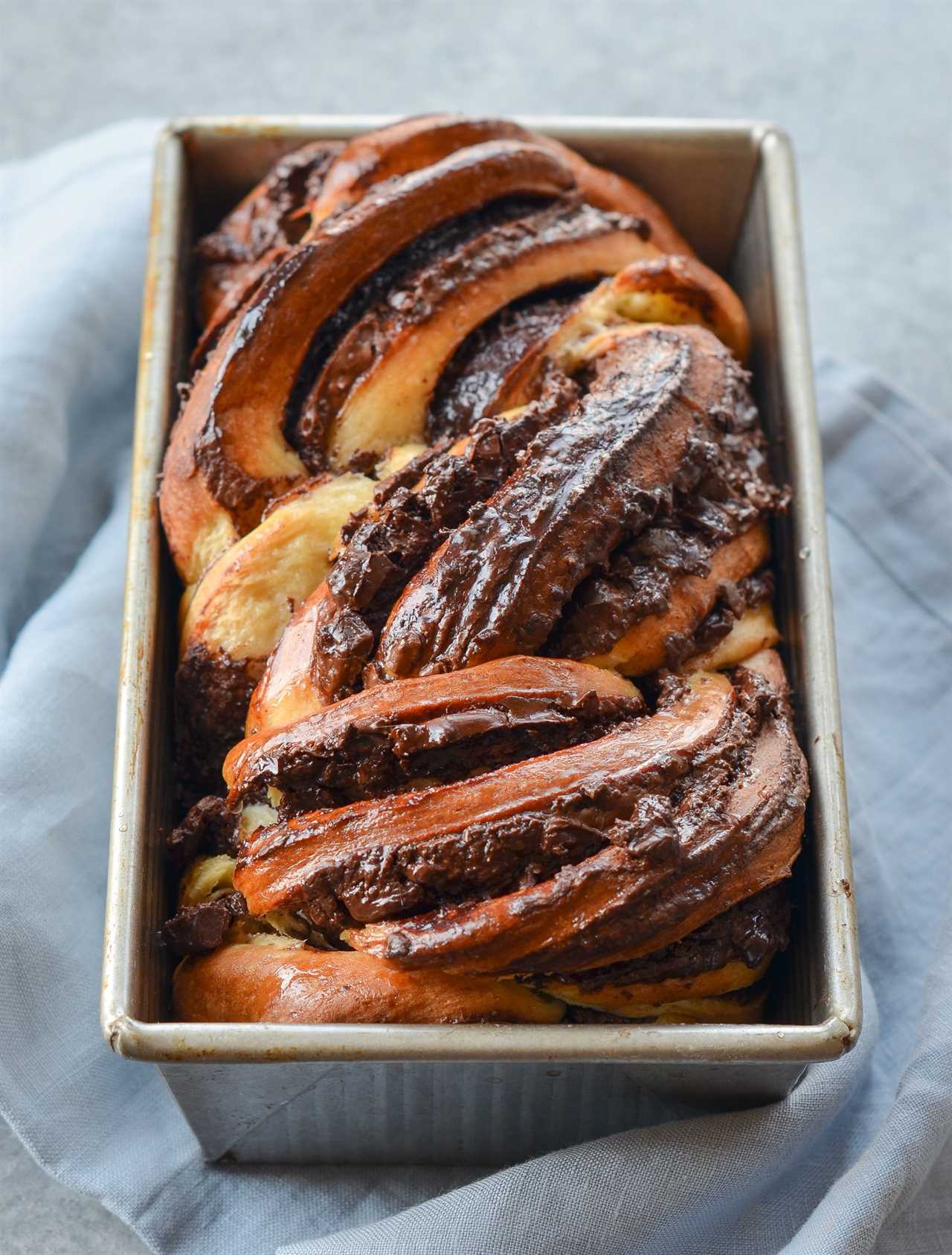 Loaf of chocolate babka in a bread pan.