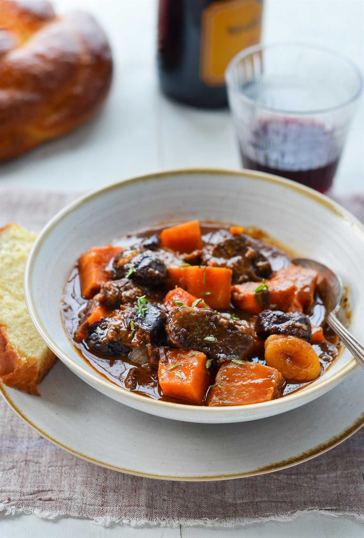 Spoon in a bowl of beef tzimmes.