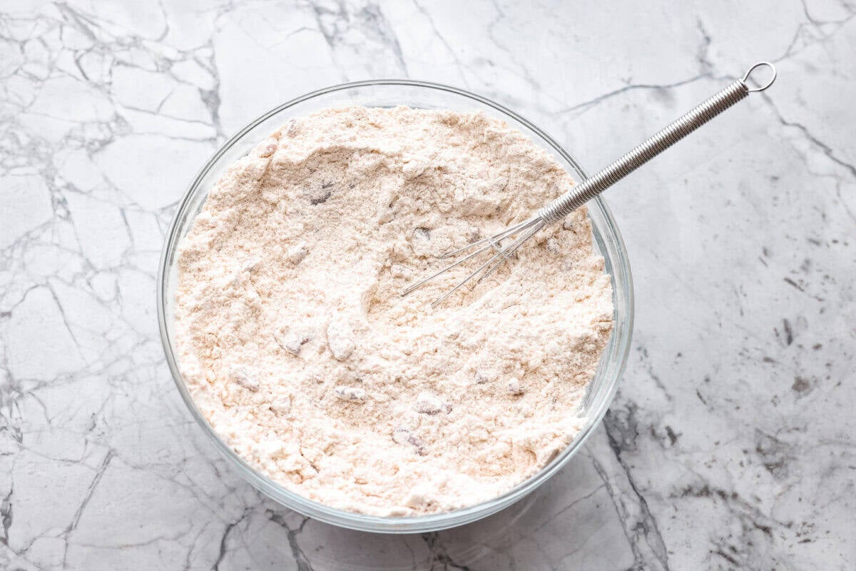Cake mix, pecans, and cinnamon whisked together in a bowl.