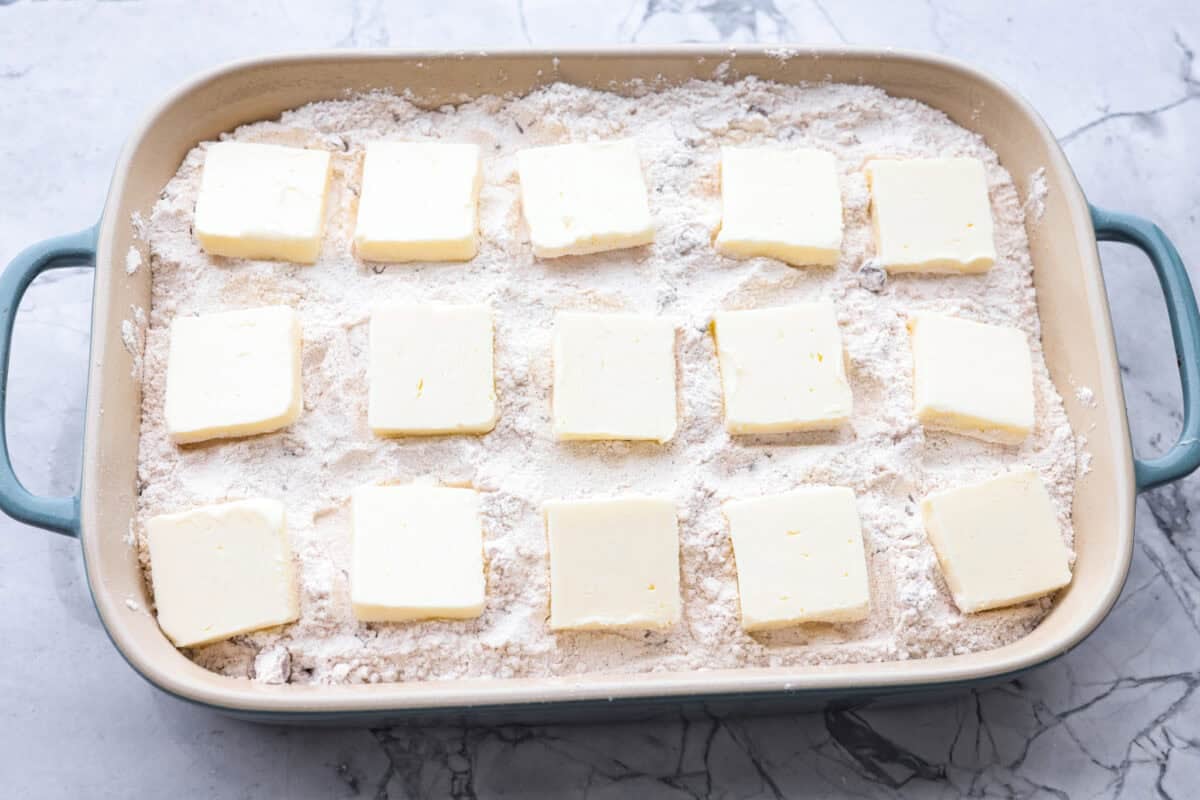 Slices of butter spread out over the top of the cake mix mixture.