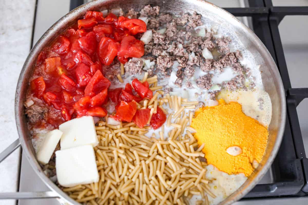 Tomatoes, butter, macaroni, powdered cheese, and milk added to the ground beef mixture. 