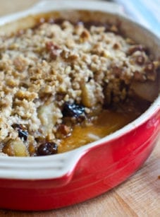 Baking dish of pear and dried cherry crisp with walnut streusel.