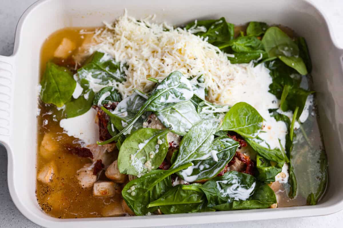 All of the ingredients including the cooked chicken dumped into a casserole dish.