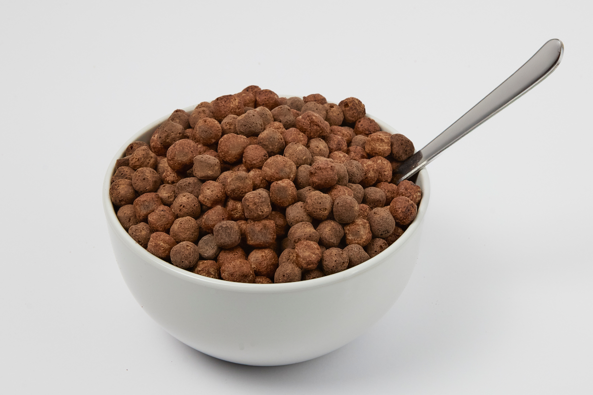 Bowl of chocolate cereal balls with a spoon. Breakfast food.