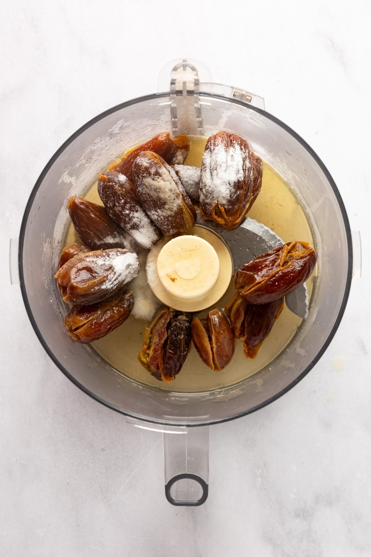 dates, cooking liquid, and baking soda in food processor bowl