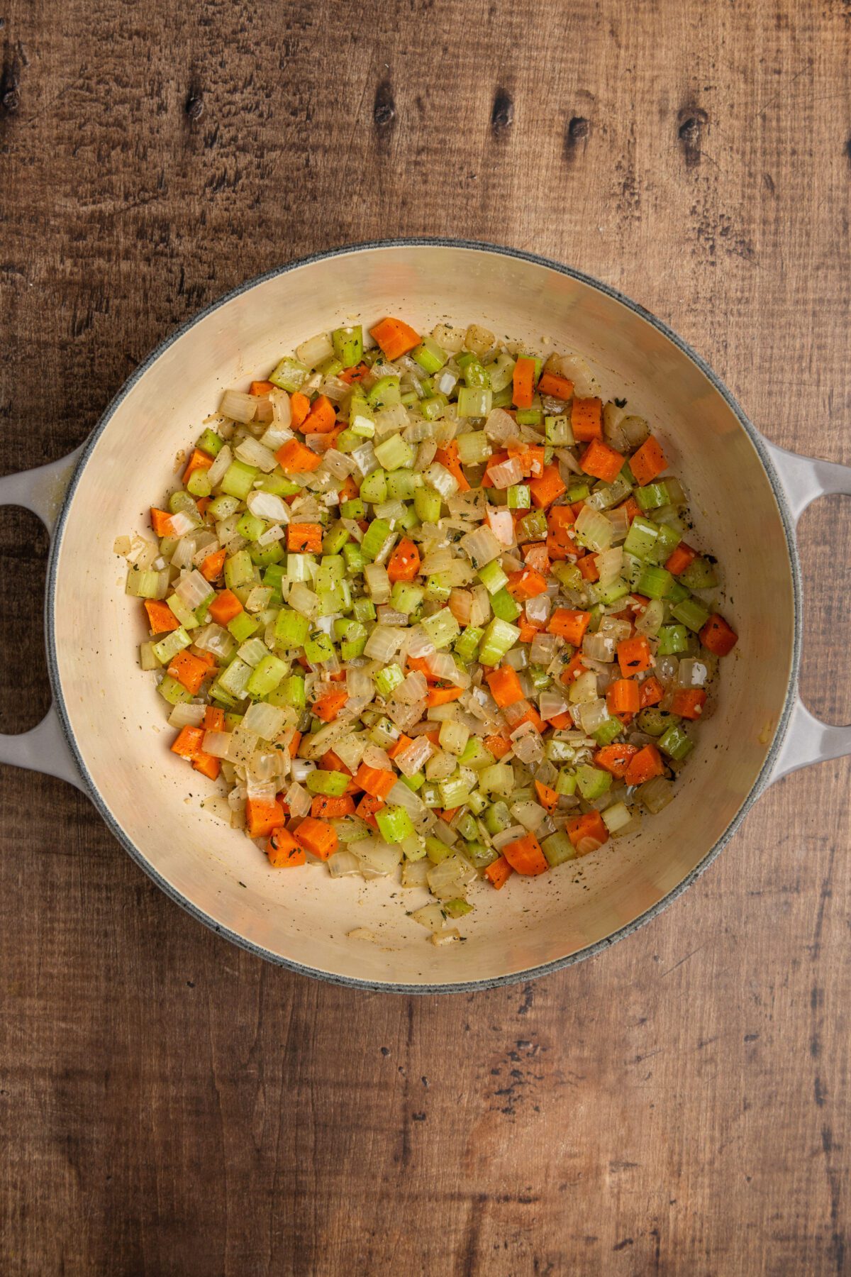 Dutch oven with softened celery, carrots, onion, garlic, thyme, salt, and pepper
