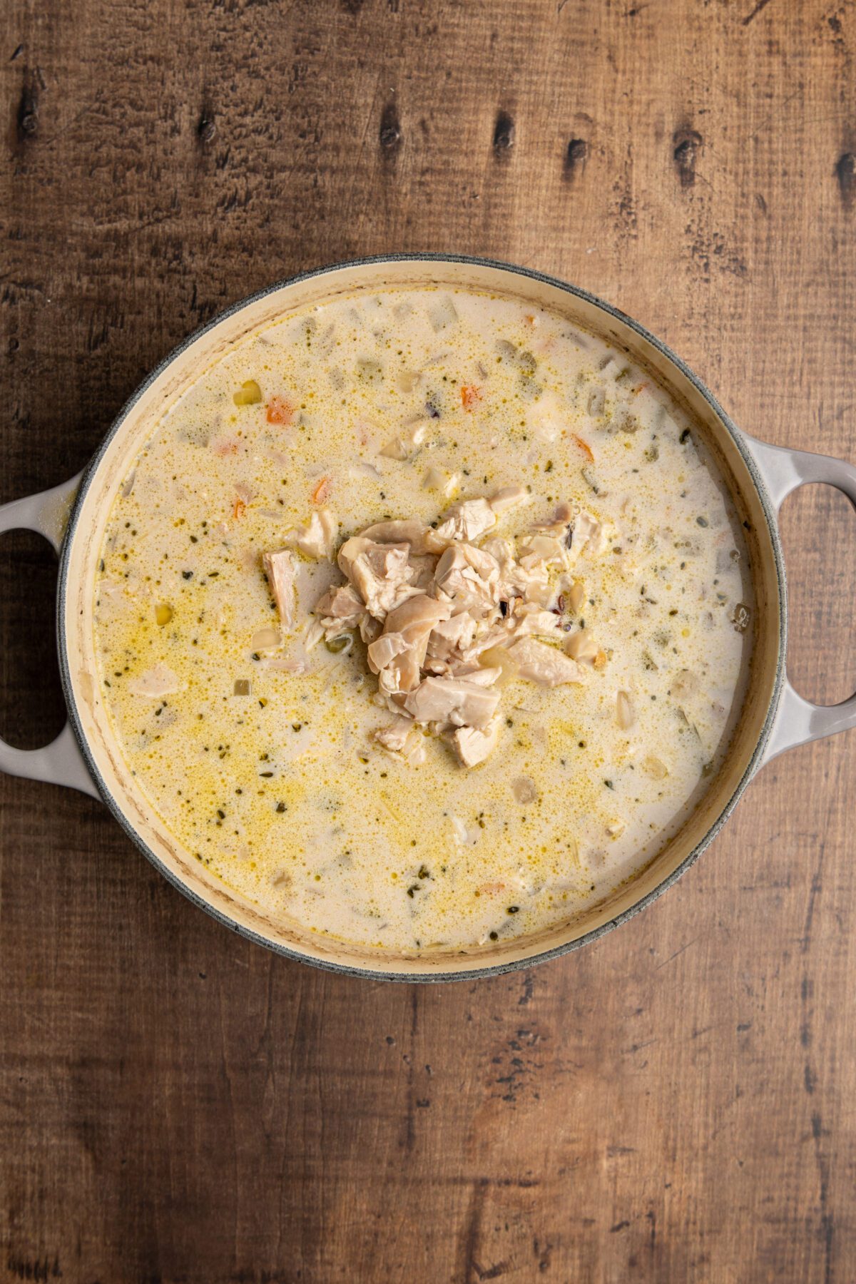 Dutch oven with chicken and heavy cream added to remaining ingredients
