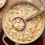 chicken and wild rice soup in Dutch oven with wooden spoon