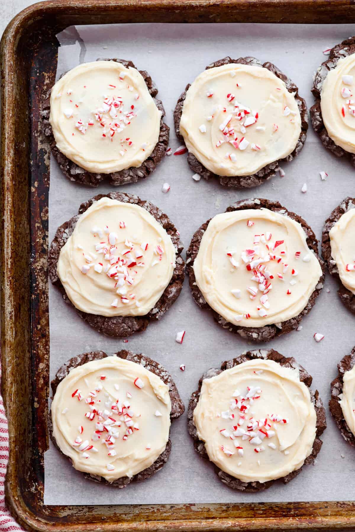 Overhead shot of frosted and crushed peppermint candied chocolate peppermint cookies on a cookie sheet.