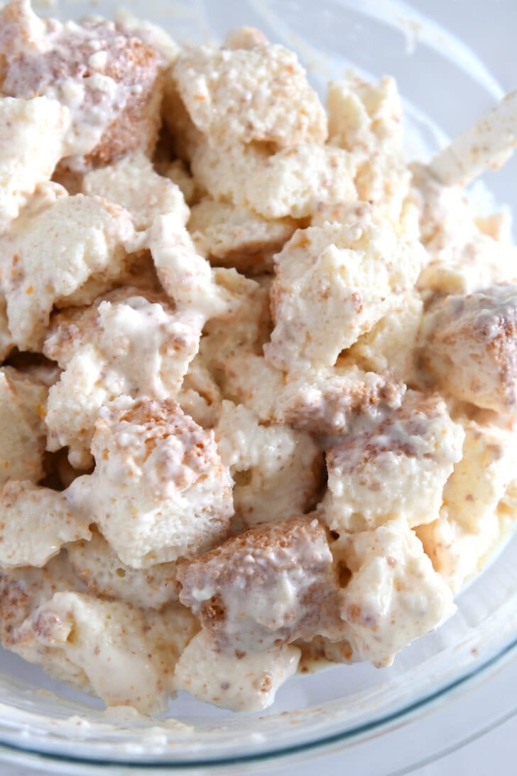 Glass bowl with angel food cake cubes tossed with cream mixture.