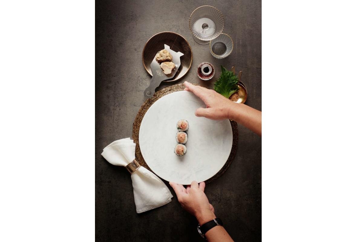 Chef Nobuya prepares Urbani Truffles sushi. Fine dining with truffle shaver, napkin, and elegant glassware. Gourmet food presentation.