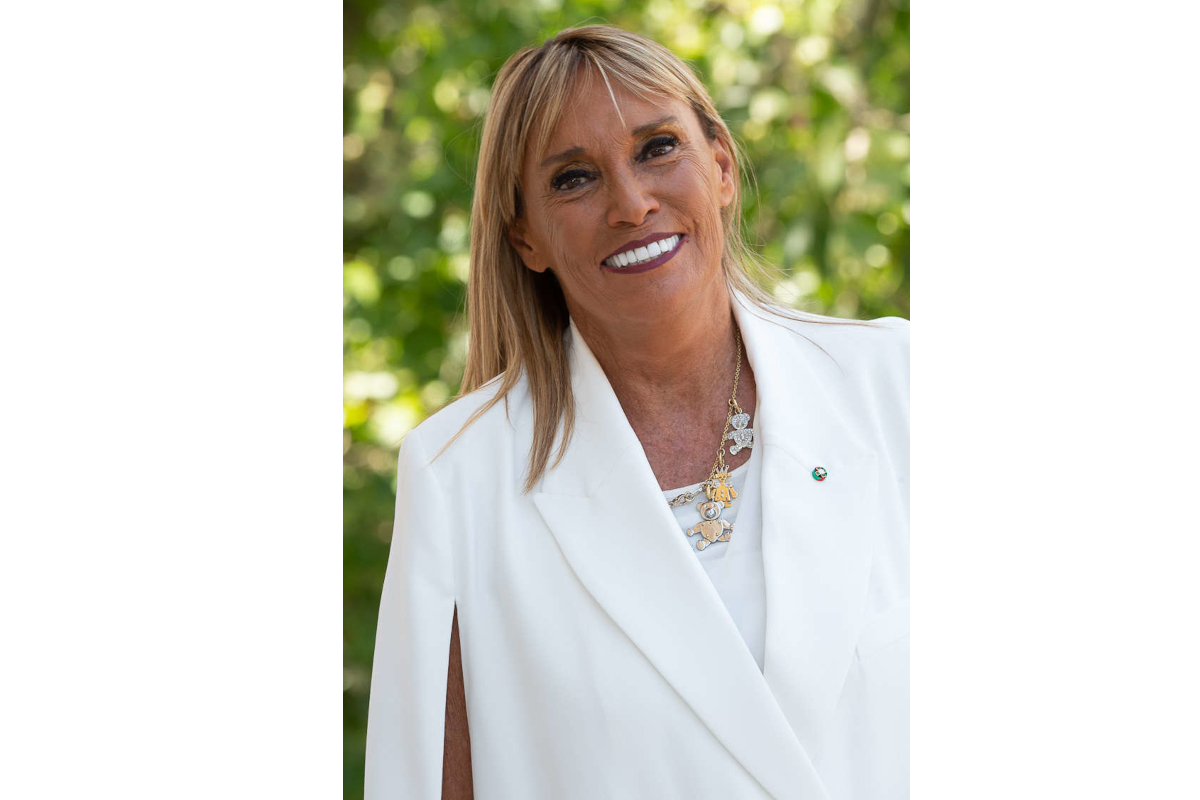 Olga Urbani, Urbani Tartufi CEO, smiling in a white blazer with a necklace.