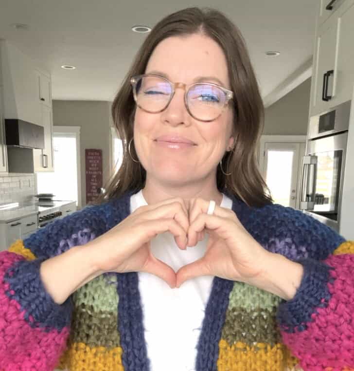 Mel holding up hand heart.