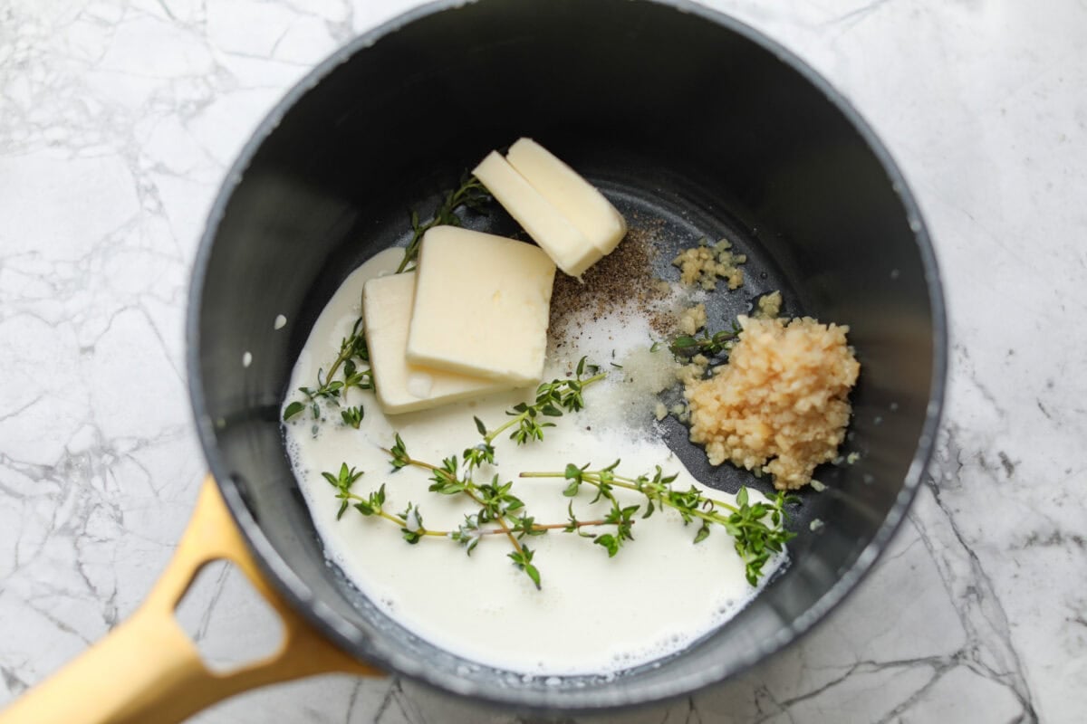 Butter, milk, garlic and herbs in a saucepan. 