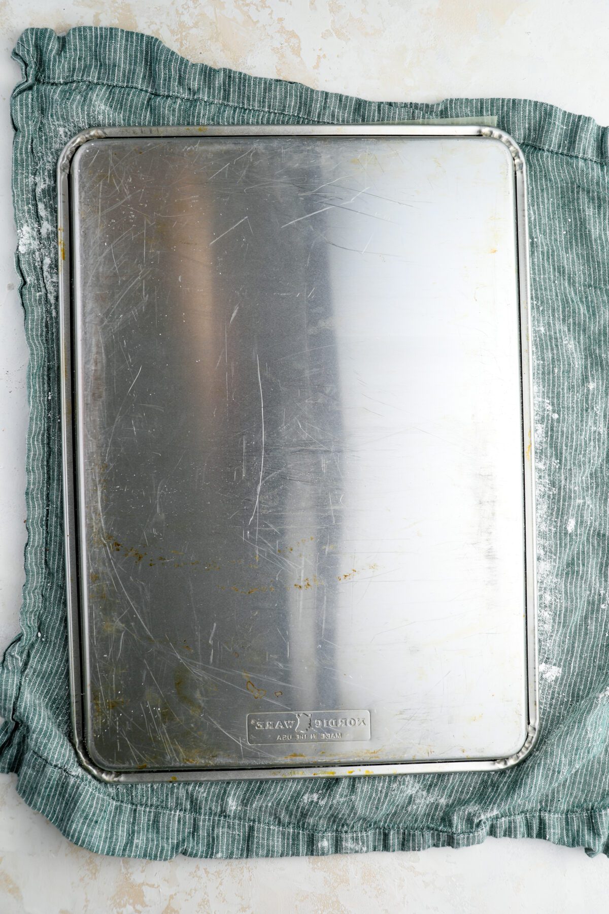 jelly roll pan with cake inverted onto clean kitchen towel