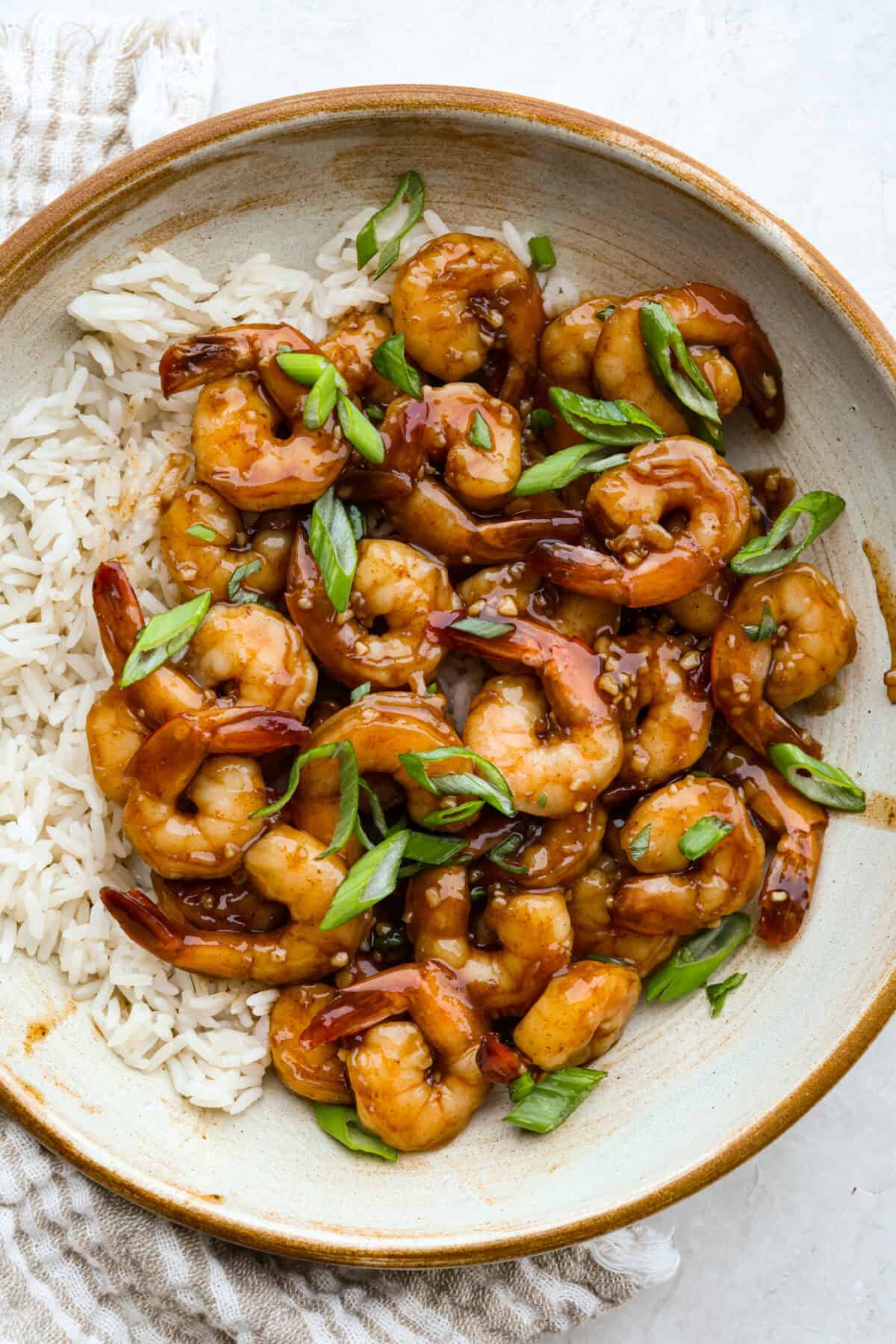 Bowl of bourbon shrimp on a bed of rice. 