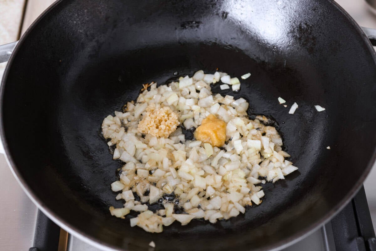 Onions, garlic and fresh ginger added to a skillet.