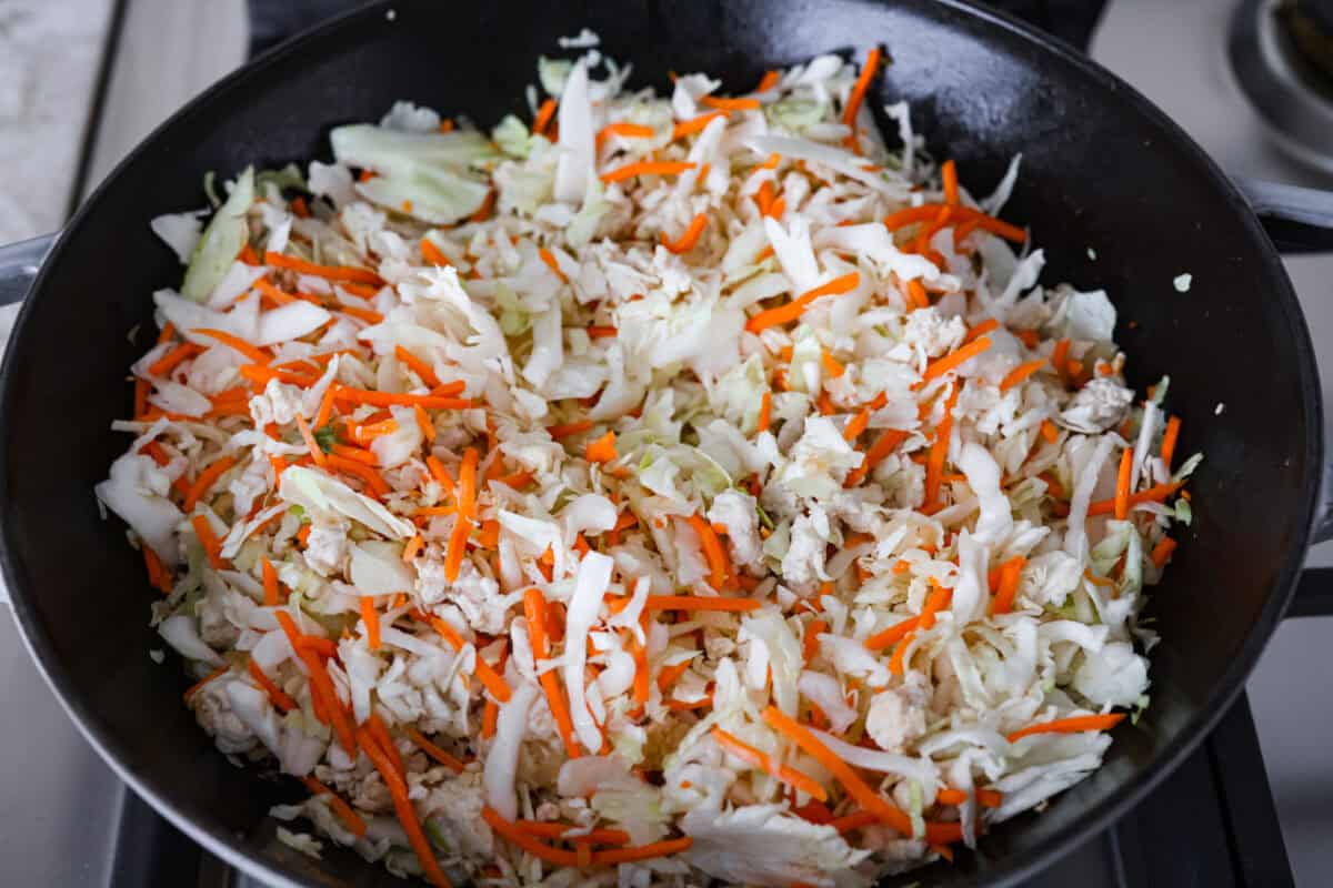 Coleslaw mix added to the skillet to cook down. 