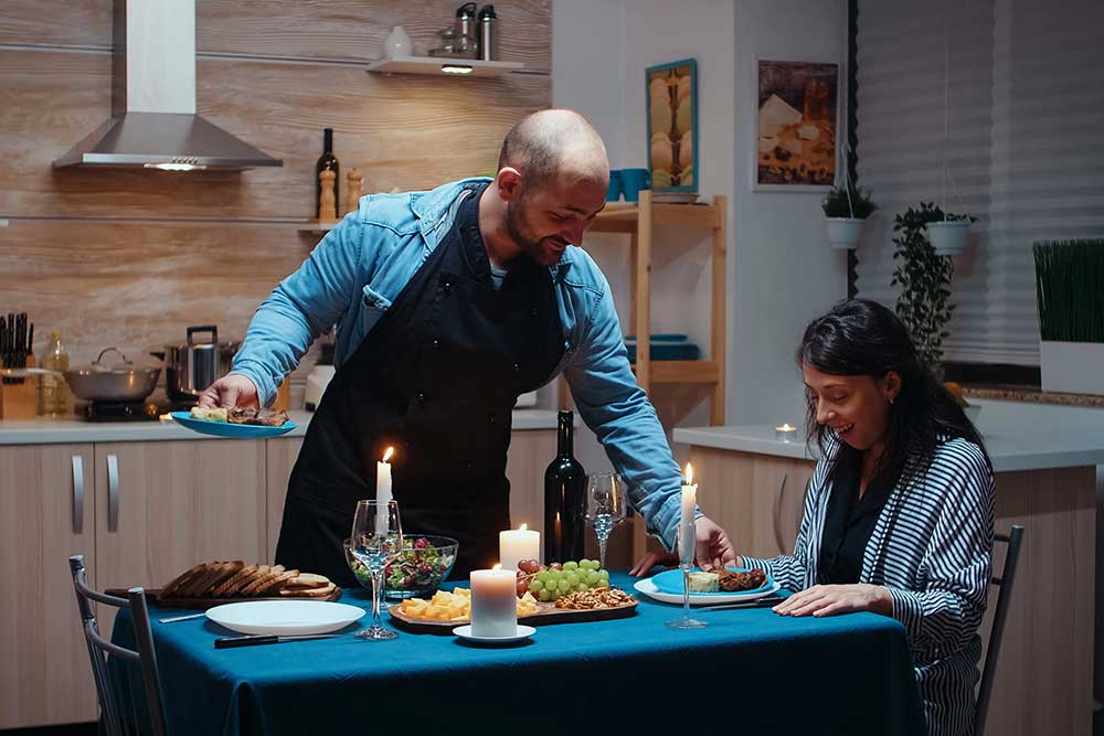couple enjoying romantic dinner for two at home with pasta and wine