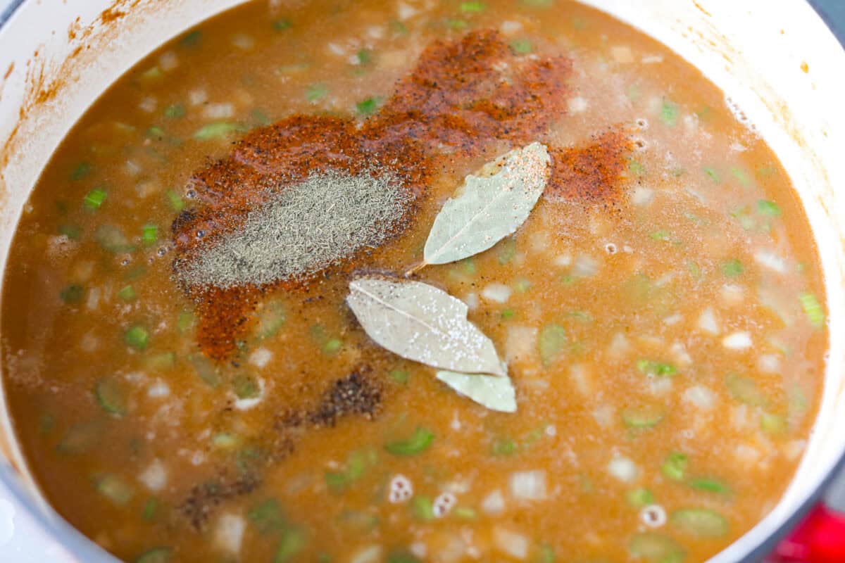 Bay leaves and seasonings added to the pot full of ingredients.