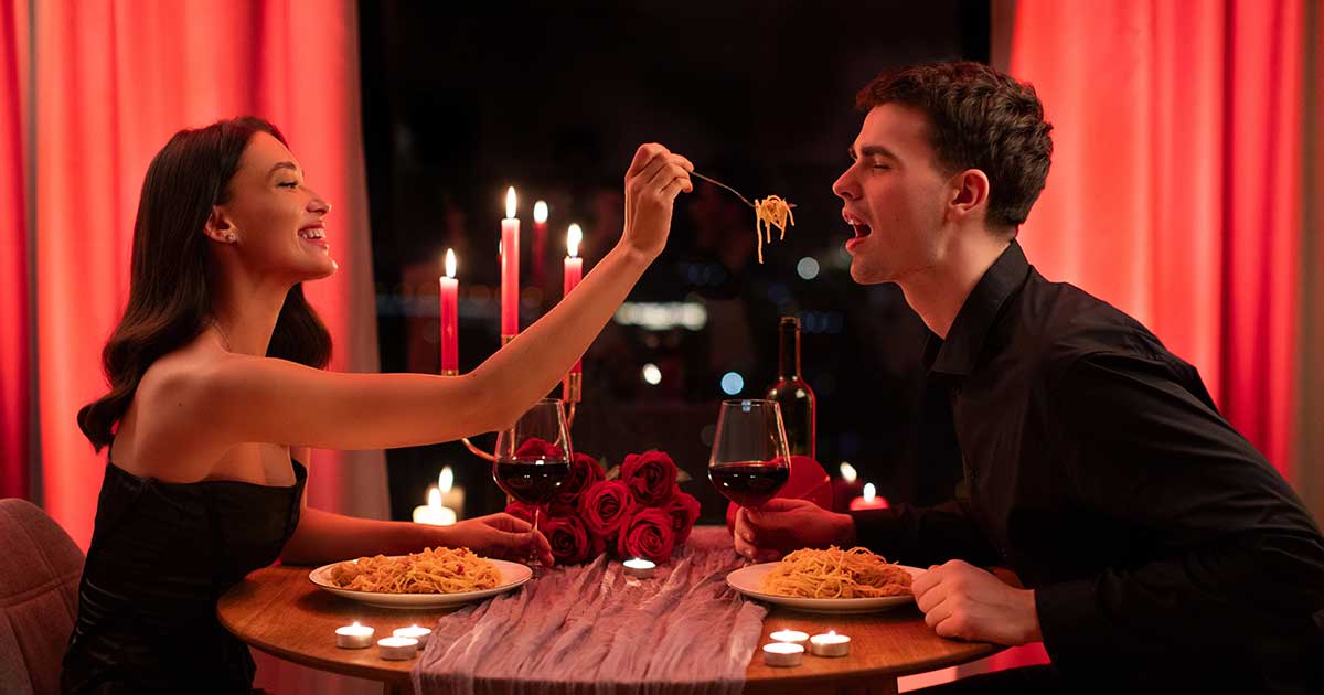 Beautifully plated pasta with Marry Me Marinara, garnished, candlelit table, wine glasses, romantic setup