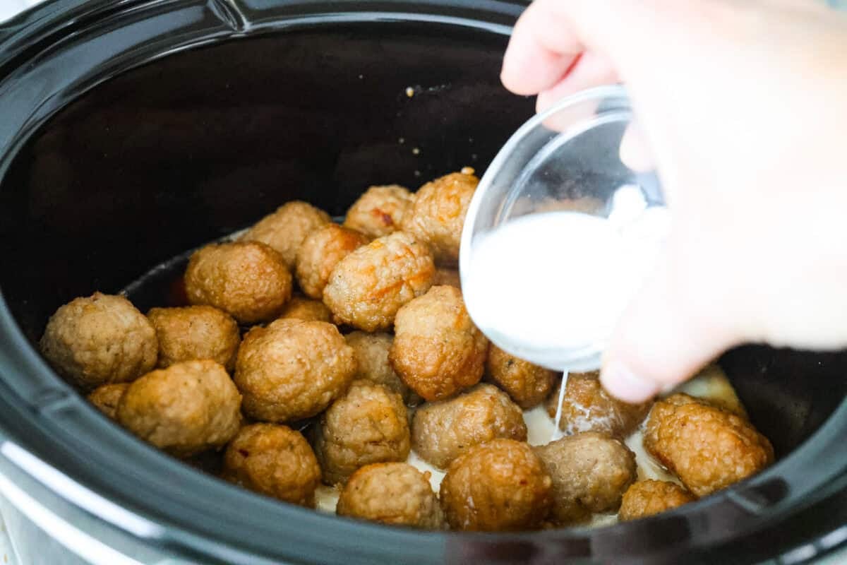 Someone adding the cornstarch slurry to the crockpot.