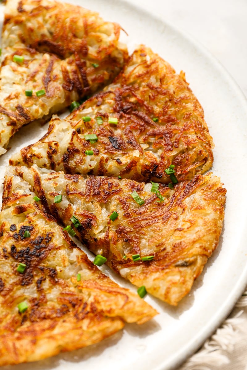 Sliced hash browns on white plate.