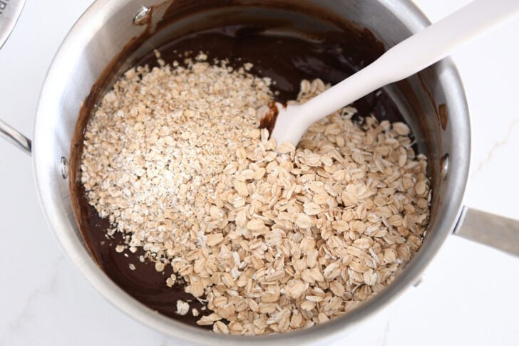 Quick oats and old-fashioned rolled oats in saucepan with chocolate no-bake cookie batter.