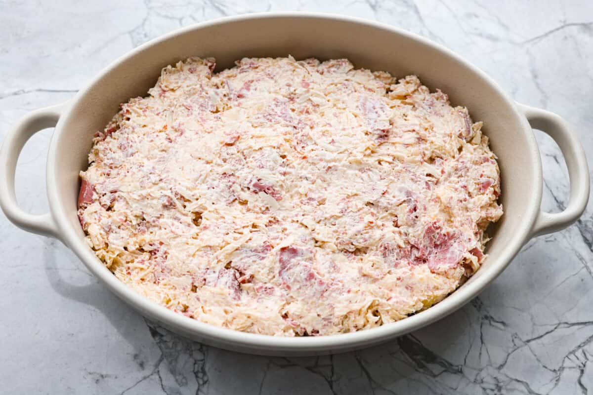 All of the dip ingredients added to a baking dish. 