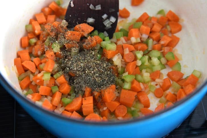 Soup pot with carrots, onions, celery, dried basil, dried oregano and dried thyme.