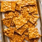 pieces of peanut brittle on parchment-lined baking sheet