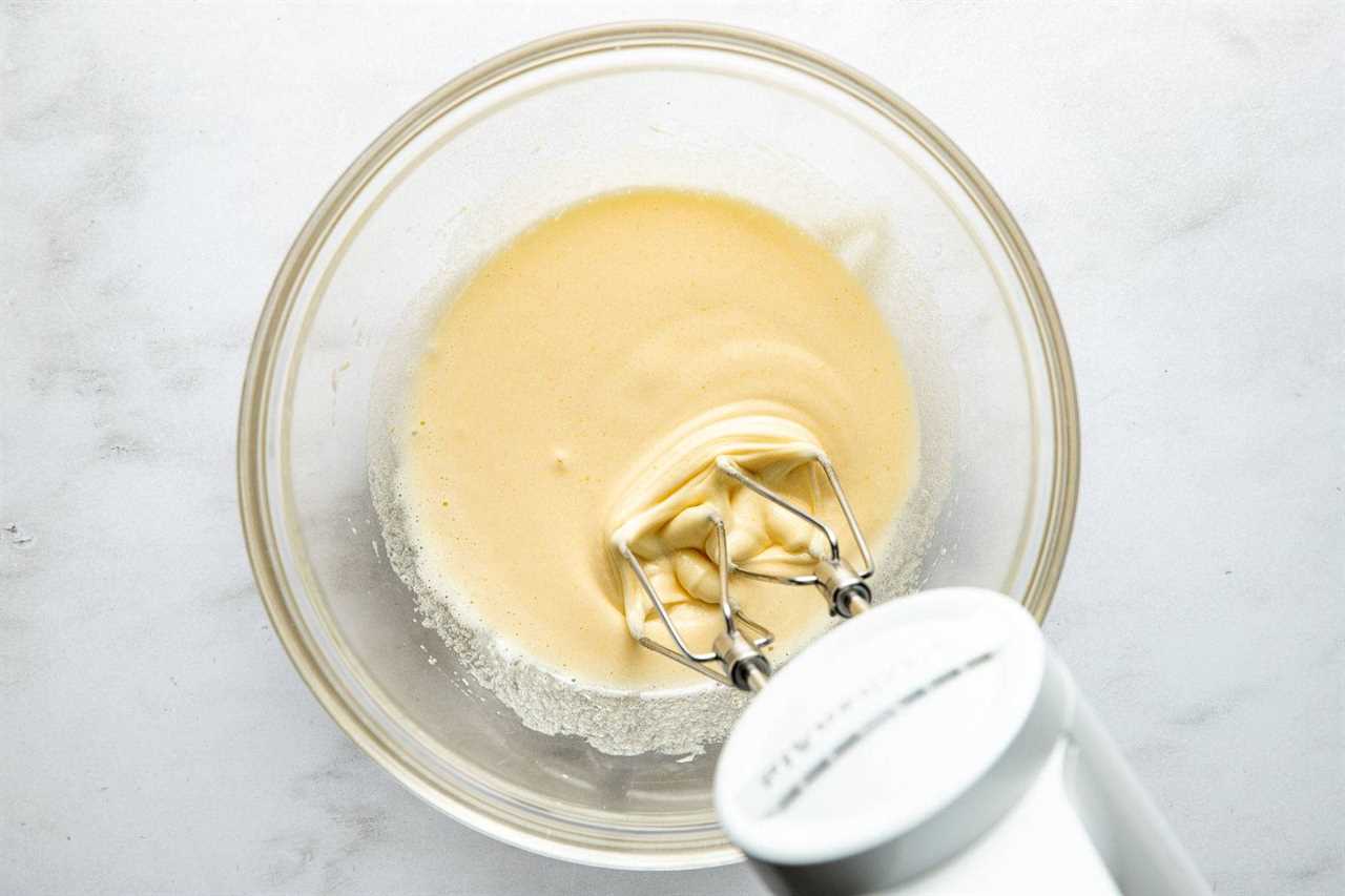 Breating eggs and sugar in a bowl.