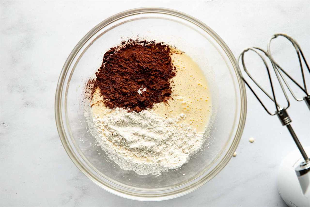 Adding cocoa powder and flour to the bowl.