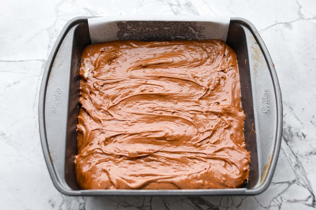 This 3 Ingredient Cool Whip Candy tastes just like a Three Musketeers! Fluffy on the inside, smooth chocolate on the outside, and so easy to make. It is the kind of treat you stash in the freezer and keep sneaking for yourself! Filling added to the prepared pan ready to go in the freezer.