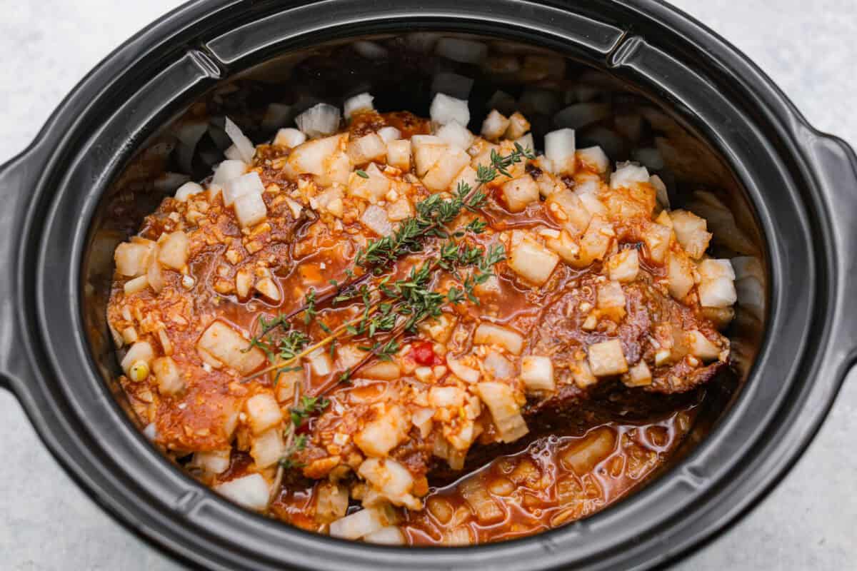 Sauce and sage added to the slow cooker with the roast and onions.