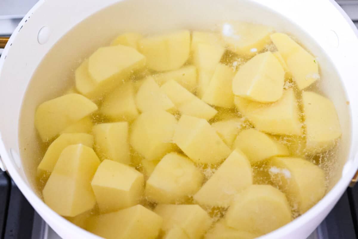 Potatoes peeled and cut up and ready to cook in boiling water. 