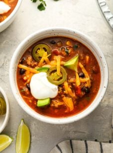 taco soup in bowl topped with cheese and sour cream