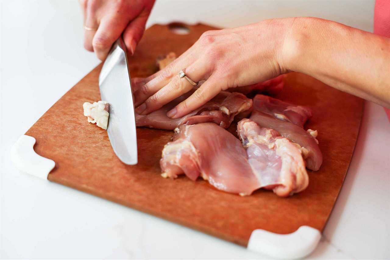 Trimming the fat off the chicken thigh