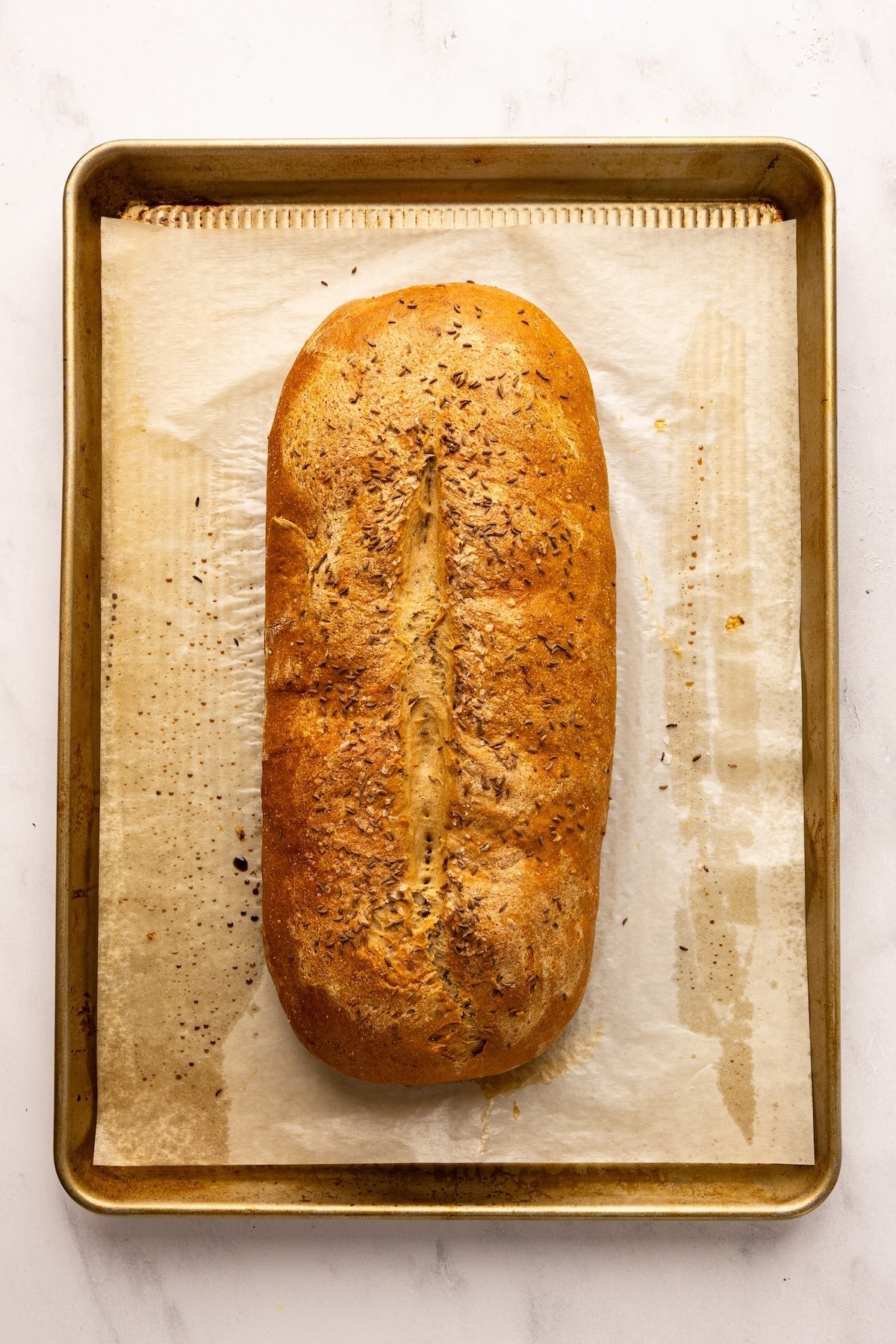 parchment lined baking sheet with baked rye bread