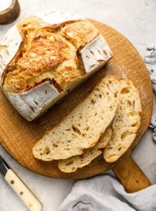 slices of sourdough bread laying next to remainder of loaf