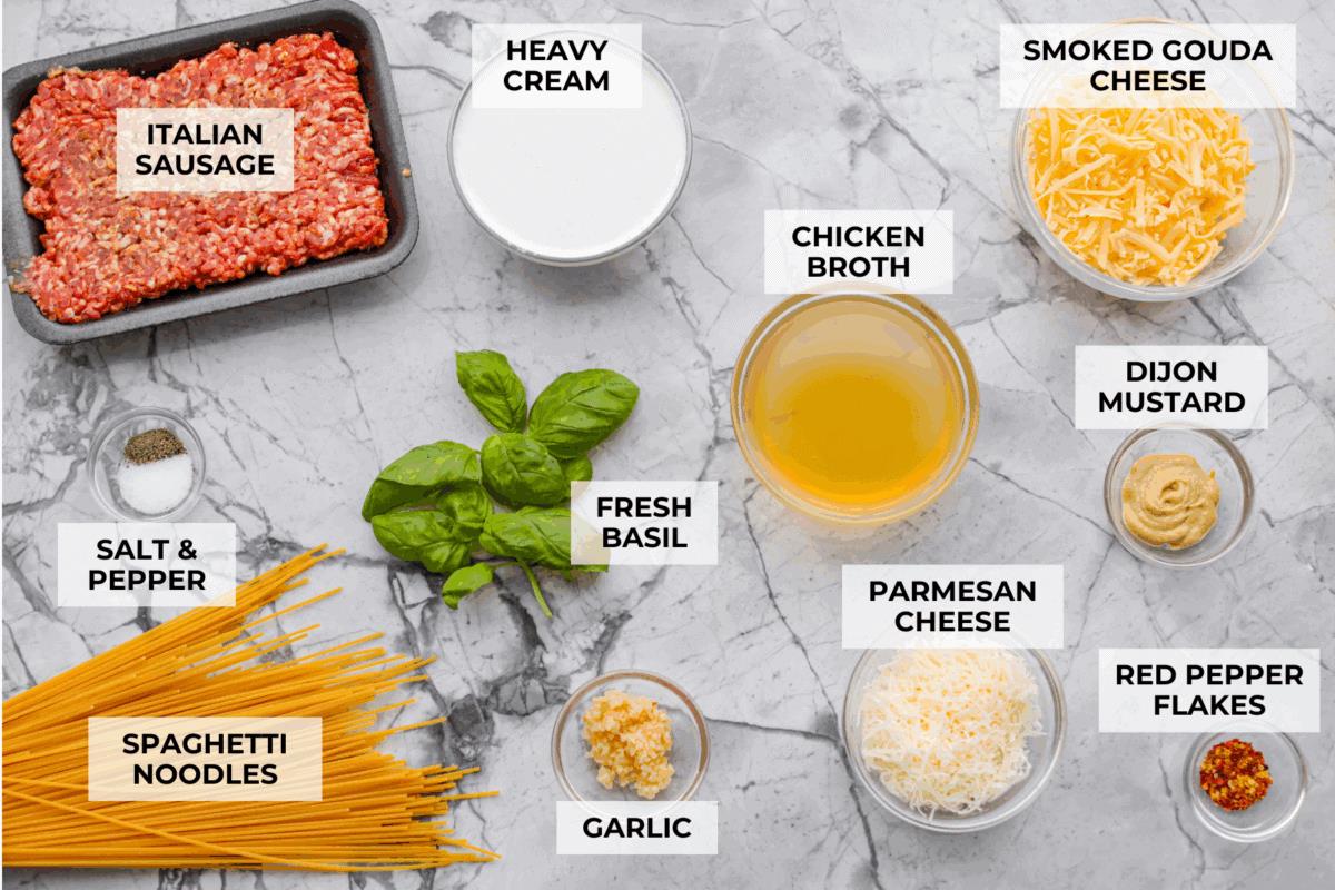 Overhead shot of labeled creamy sausage spaghetti ingredients. 