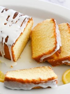 Partially sliced lemon pound cake on a plate.