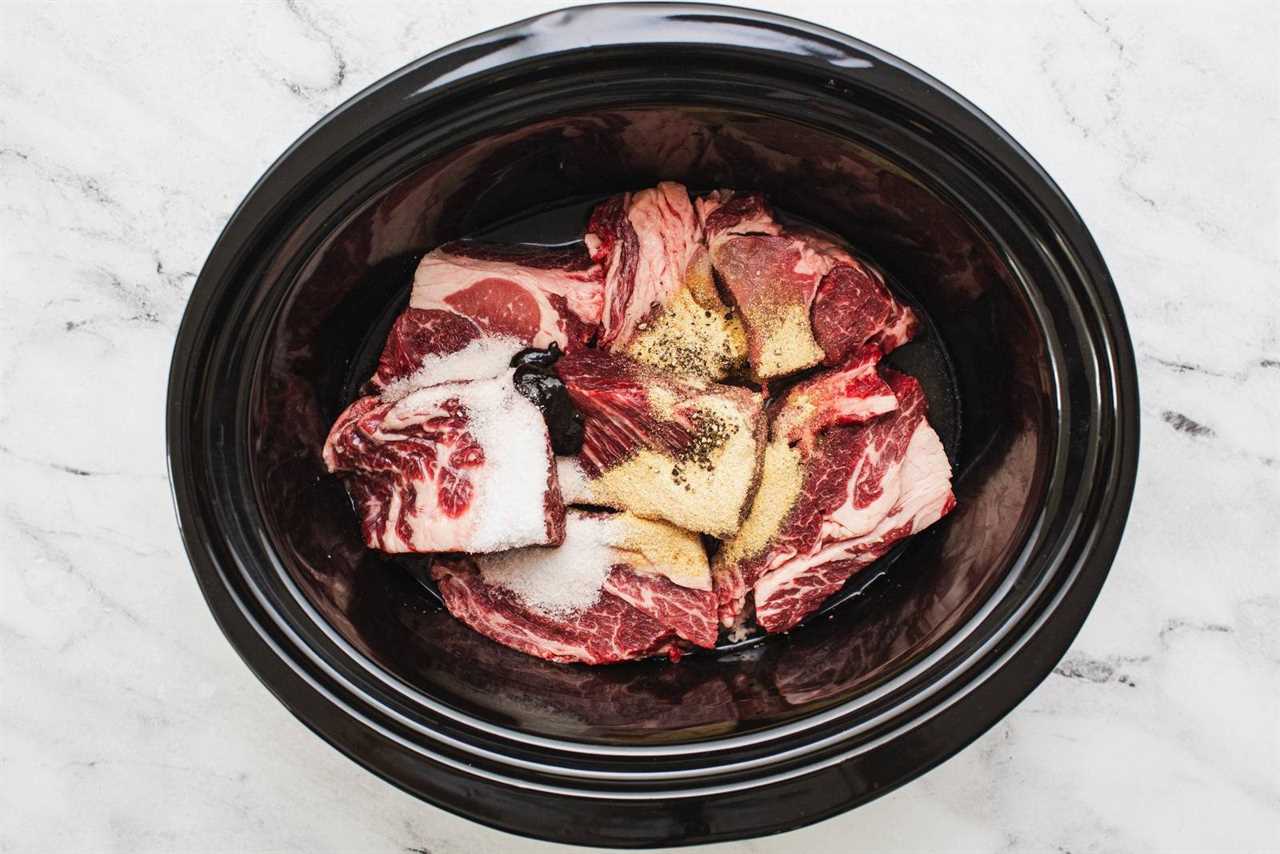 Beef and seasonings in a crockpot.