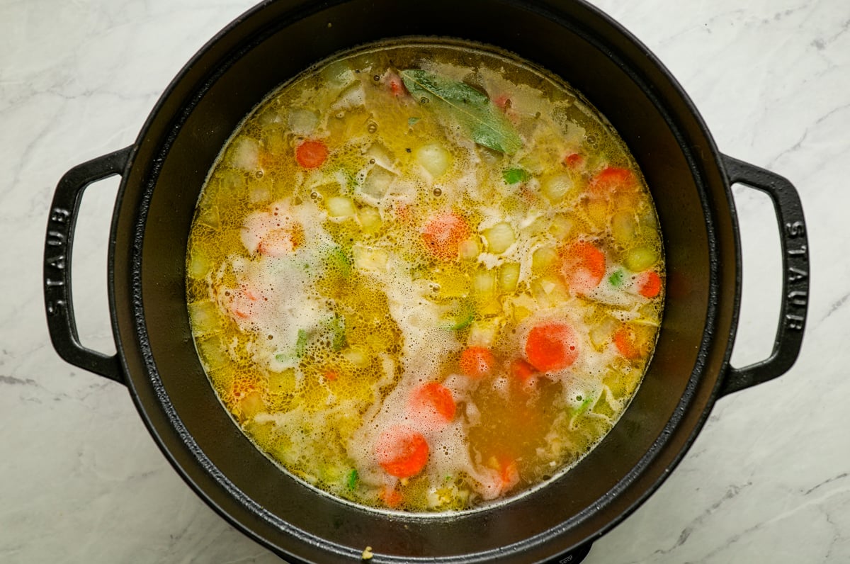 simmering chicken broth and veggies in pot